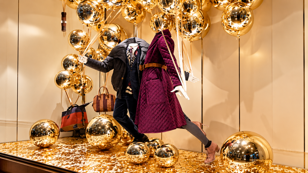 Luxury retail window display with gold decorative spheres and custom visual merchandising props